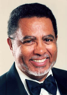 African American composer Adolphus Hailstork, wearing a black tuxedo, against an ivory colored background