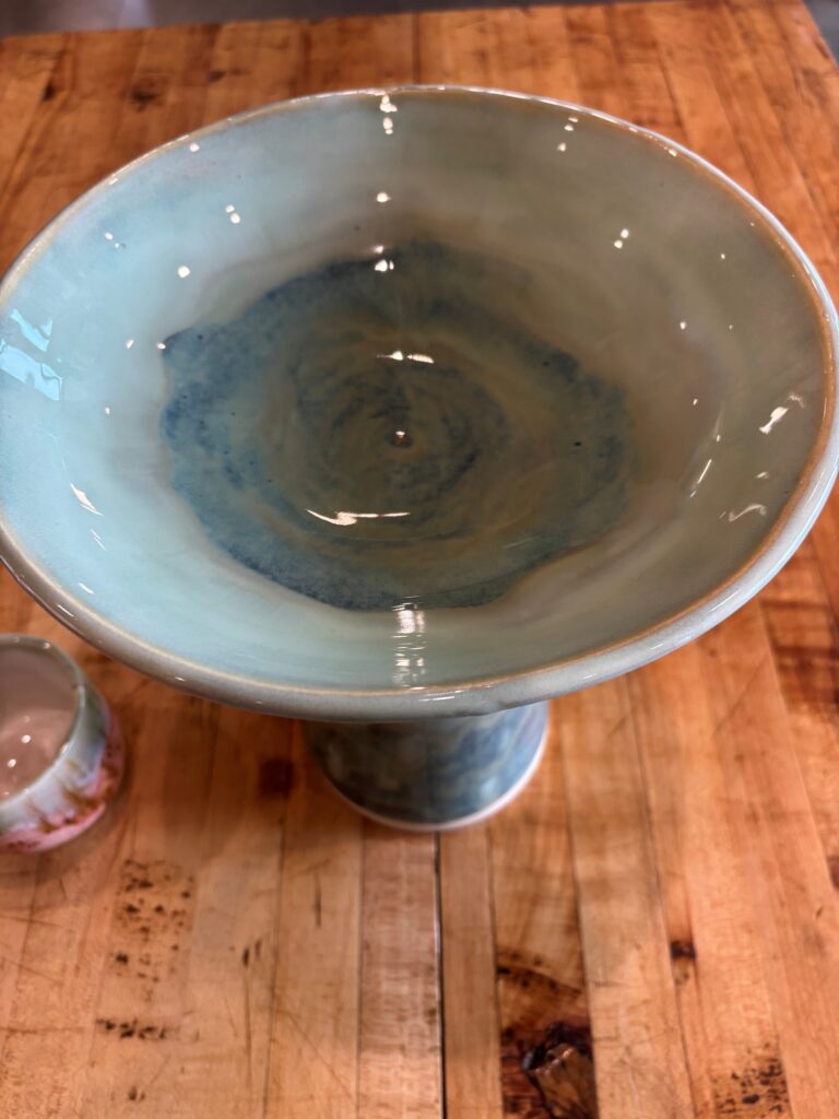 The inside of the wide bowl shows a variegated darker blue center and lighter blue towards the top of the bowl